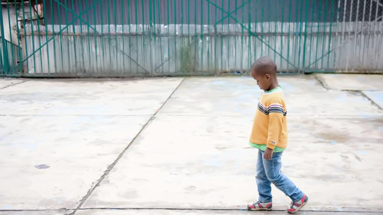 Solitary child walking with head down